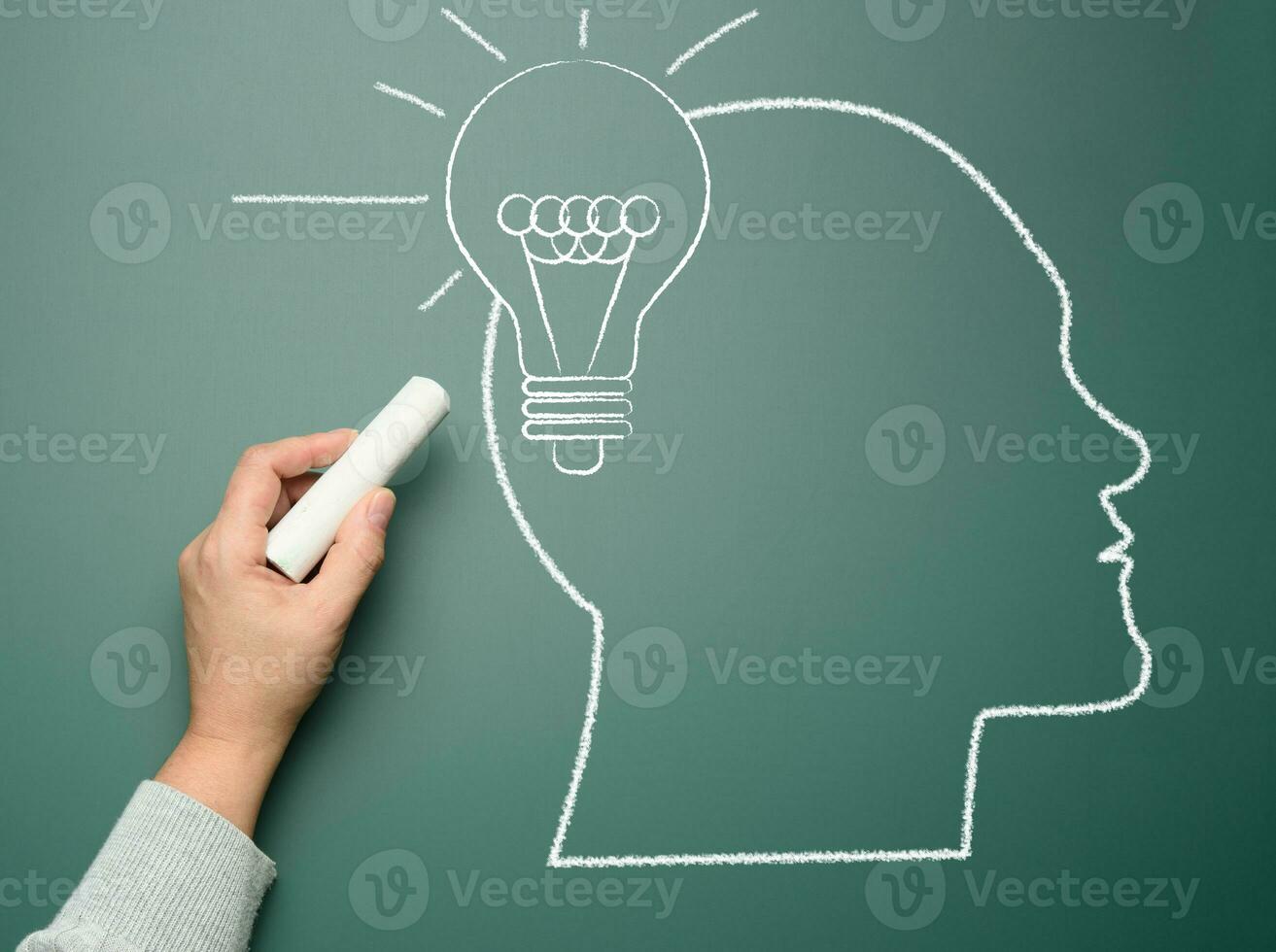 Silhouette of a human head drawn with chalk and an electric lamp, concept of searching for creative ideas photo