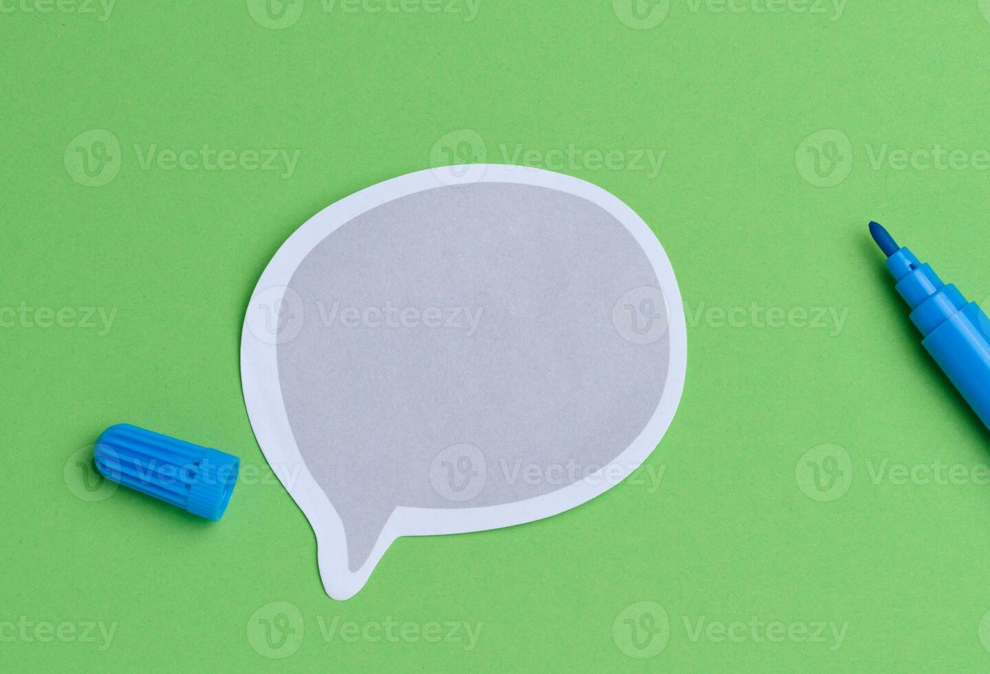 Paper sticker and blue felt-tip pen on green background, top view photo