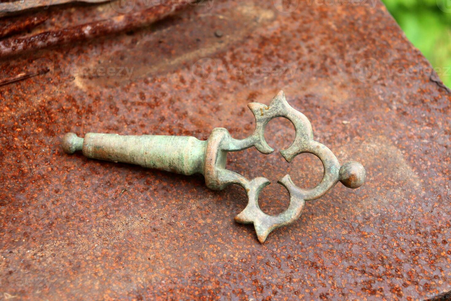 An old metal village handle from a samovar - a device for boiling water for tea. Part of the samovar - the tap handle - close-up, horizontal photo. photo