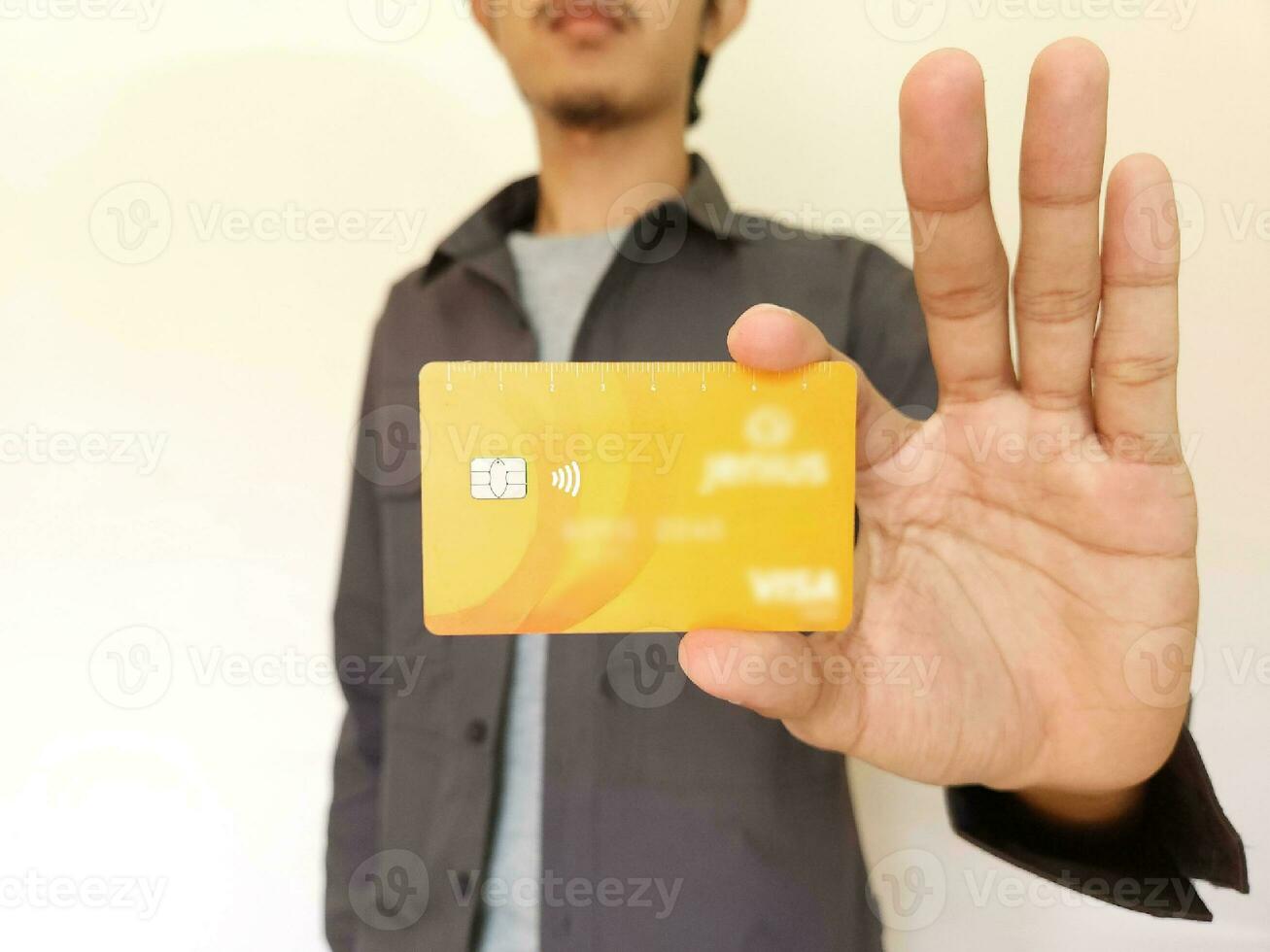 Man Holding and showing an orange credit card photo