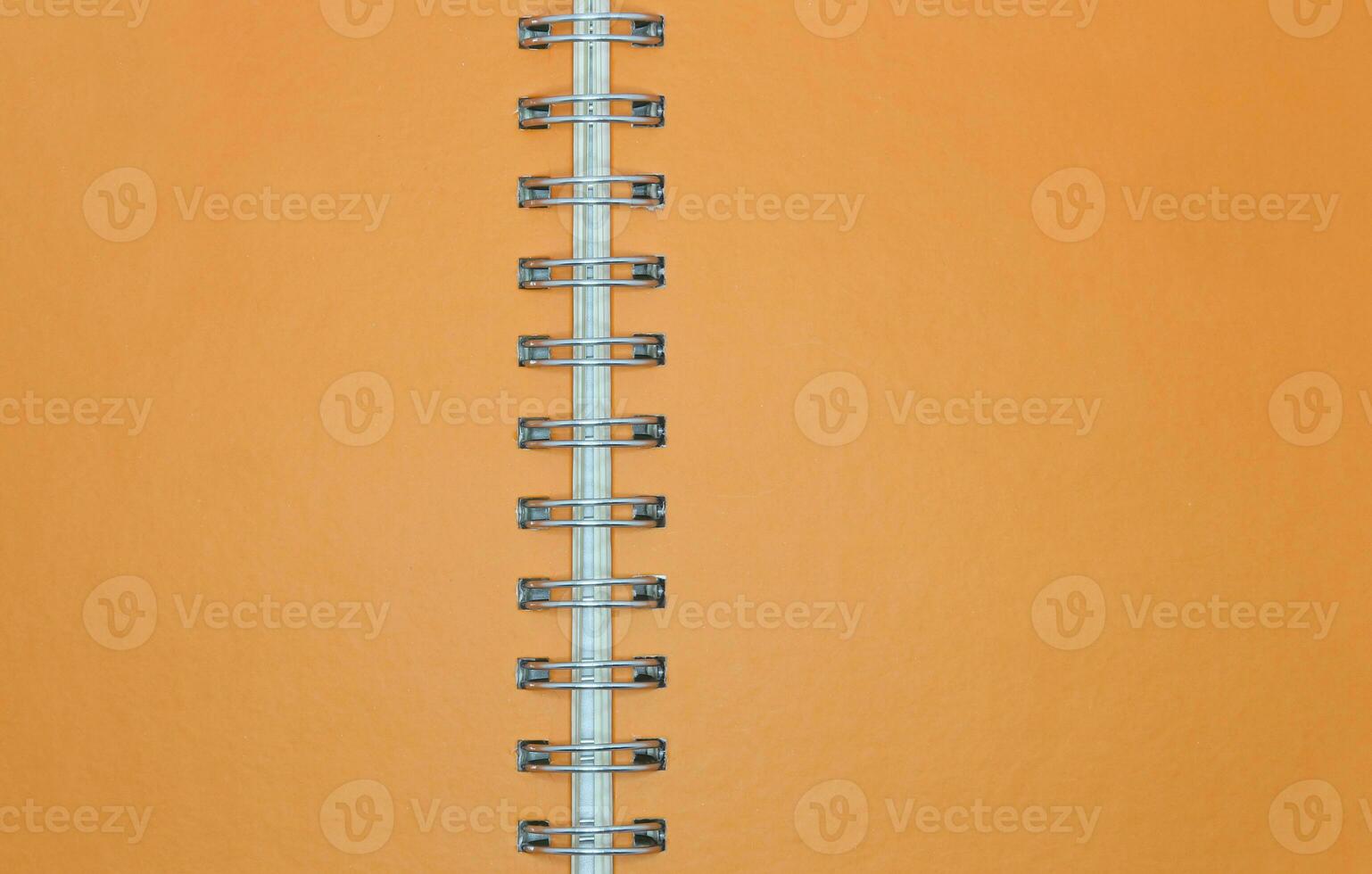 Blank orange notebook paper with ring spine for background photo