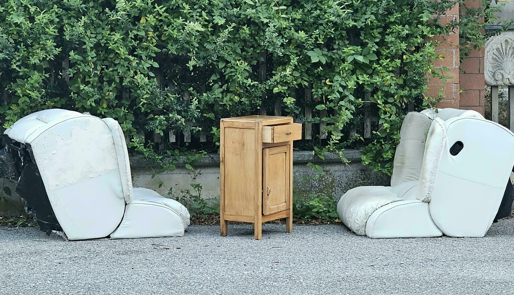 old furniture waiting to be taken away like rubbish in the landfill, in an Italian municipality in the summer of 2023 photo