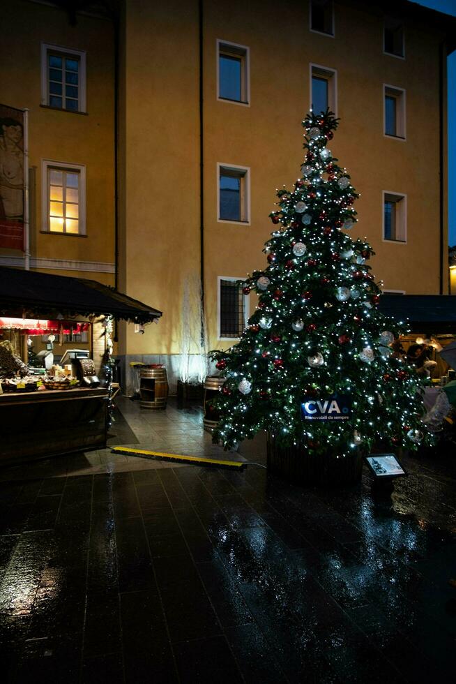 Christmas trees decorated with holiday lights and ornaments in the various Christmas markets in Italy during the Christmas holidays photo