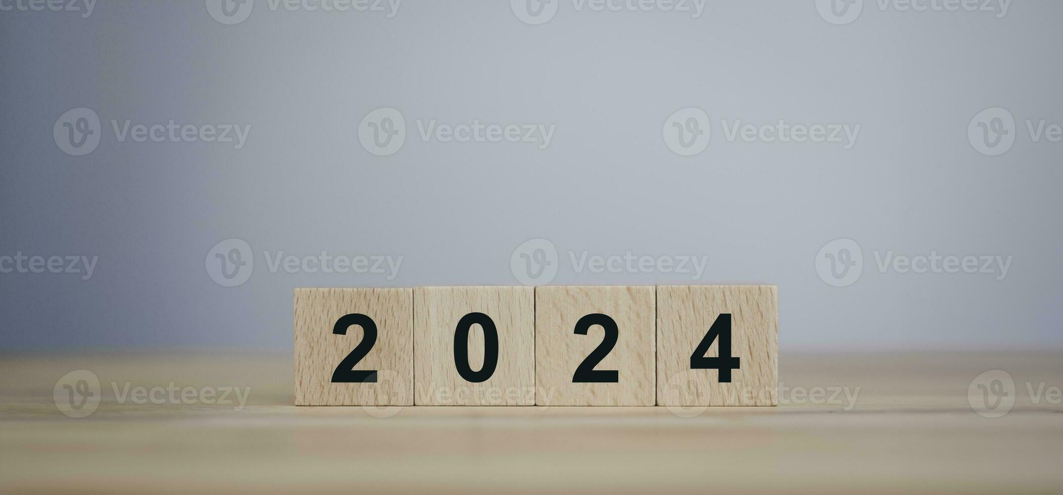 From 2023 to 2024. Merry Christmas and Happy New Year, numbers on wooden cube blocks on wooden table with copy space. 2024 new year idea concept. photo