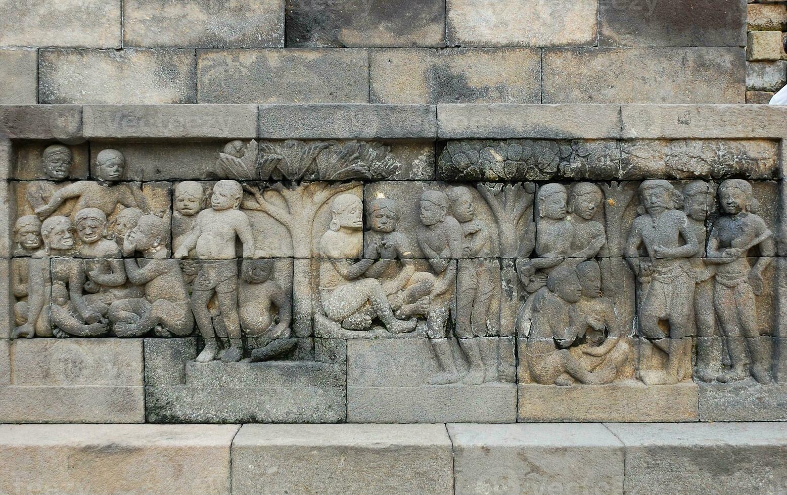 Bas-relief sculptures on wall at encased foot of Borobudur, Indonesia photo