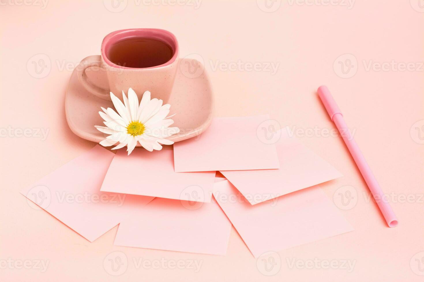 The concept is pink. Pink drink in a coffee cup, sheets for writing, a pen and a chrysanthemum on a pink background. photo