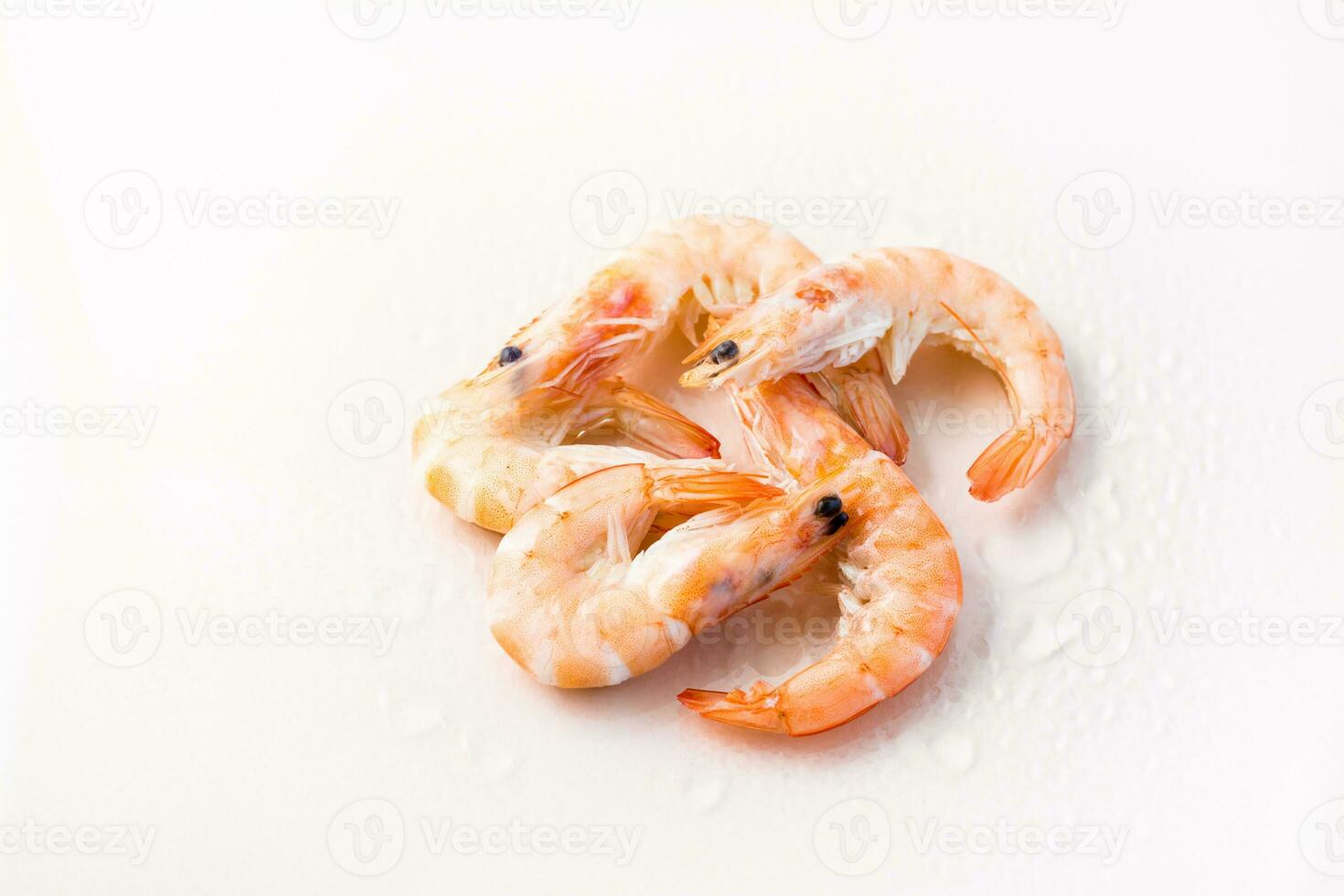 Raw thawed prawns with water drops on a pink background. Mediterranean food photo