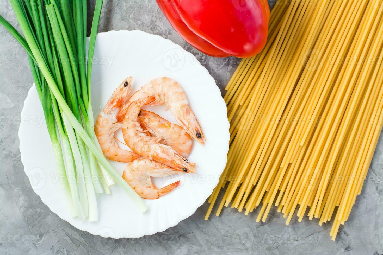 Ingredients for making udon and wok noodles with shrimps, peppers and onions on the table. Chinese food. Top view photo