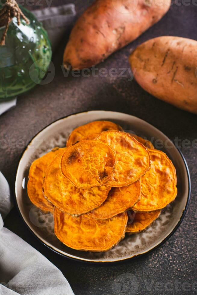 Homemade sliced baked sweet potato on a plate on the table vertical view photo