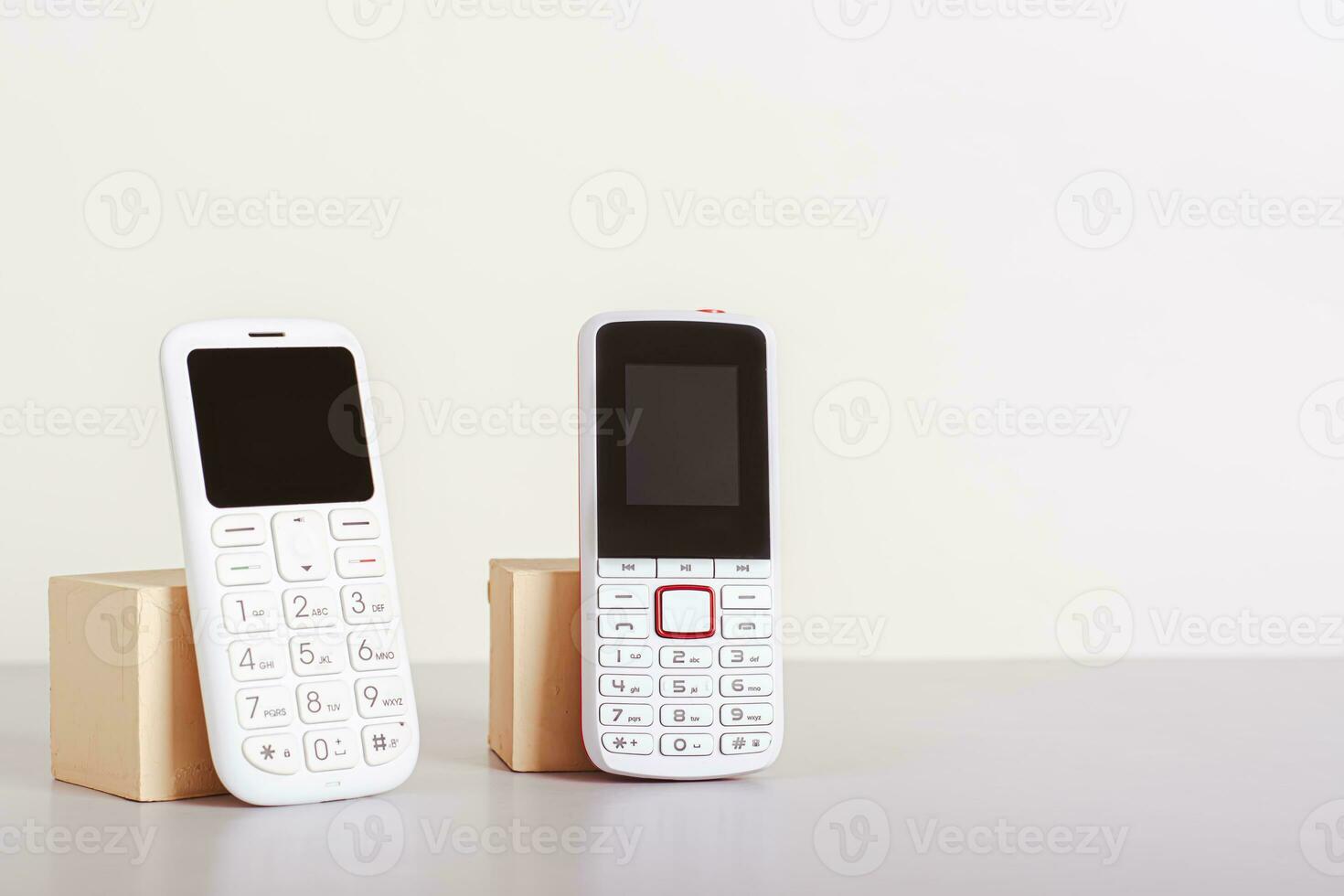 Two old-fashioned white push-button telephones are on the table photo