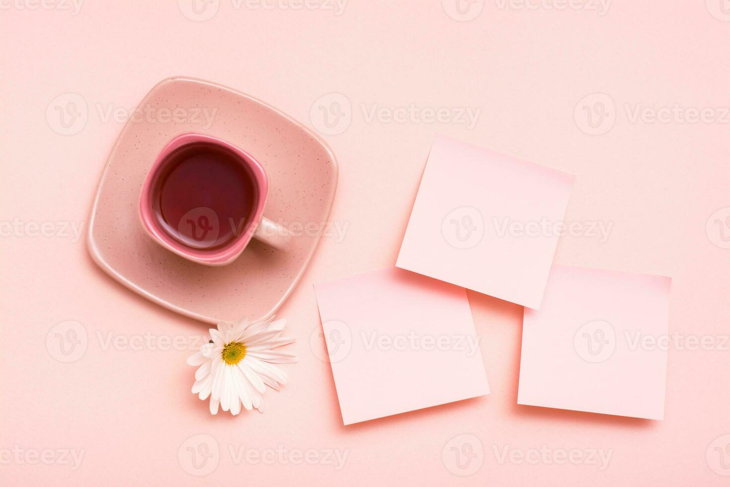 The concept is pink. Pink drink in a coffee cup, leaf for writing and chrysanthemum on a pink background. Top view. Copy space photo