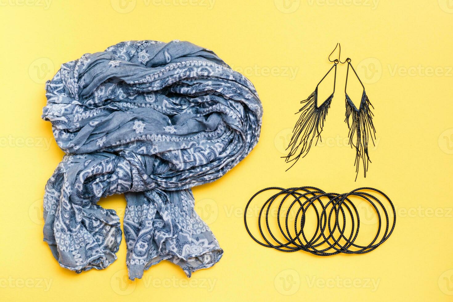 Beautifully curved cotton neck scarf, bracelets and earrings on a yellow background. Spring outfit, fashion accessories photo