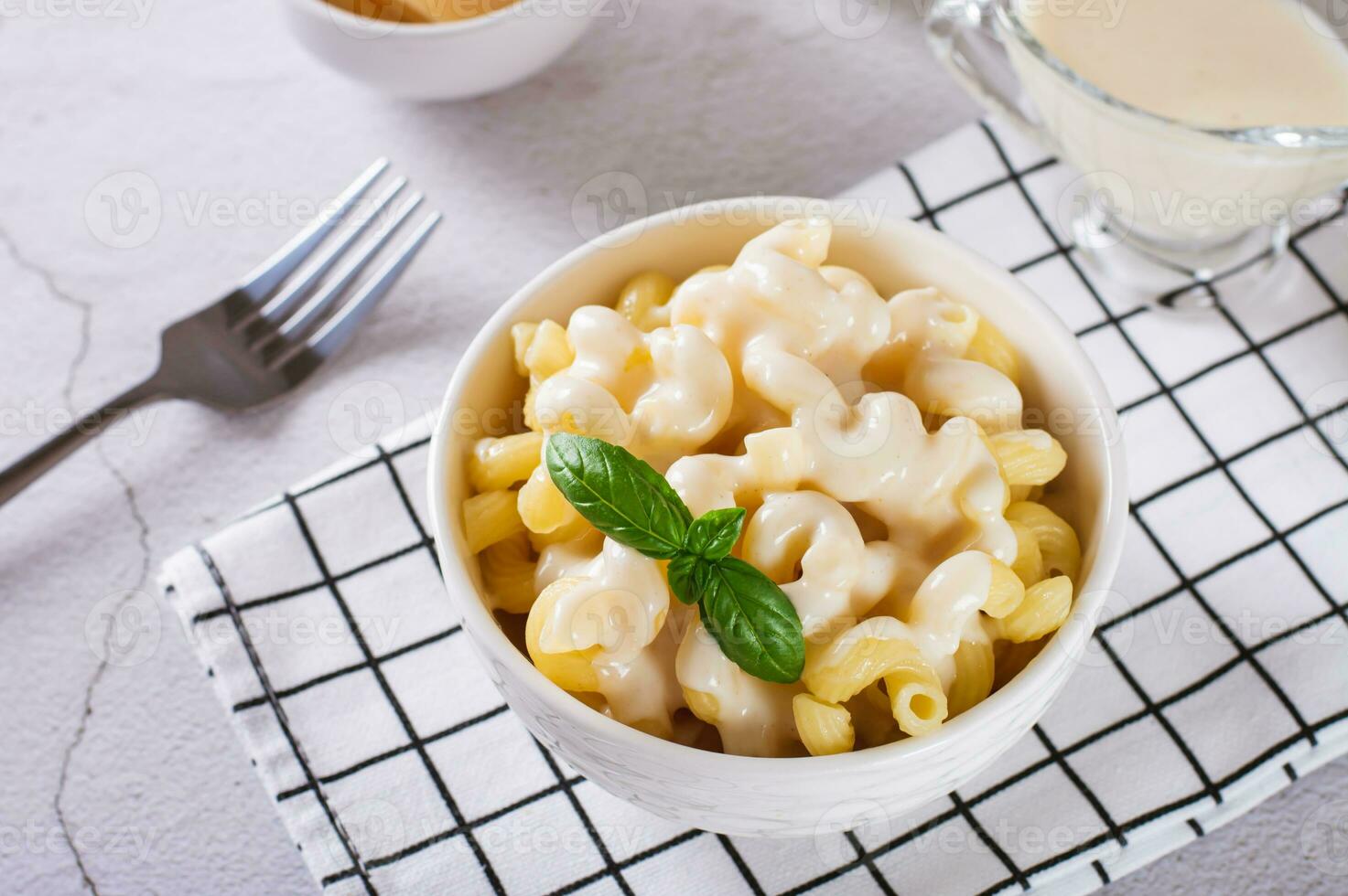 American pasta in a cheese sauce with basil leaves in a bowl photo
