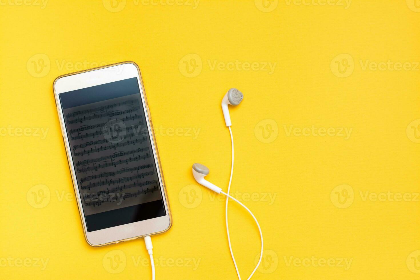 Listening to music using a smartphone and wired headphones. Leisure with gadgets. Top view photo