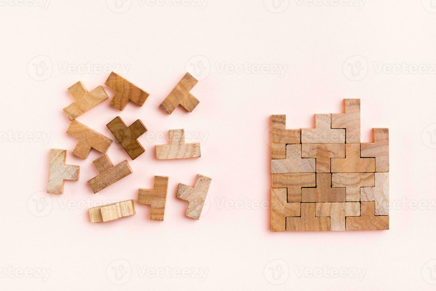 Organization and order. Wooden puzzle pieces are stacked correctly and chaotically scattered in disarray on a pink background photo