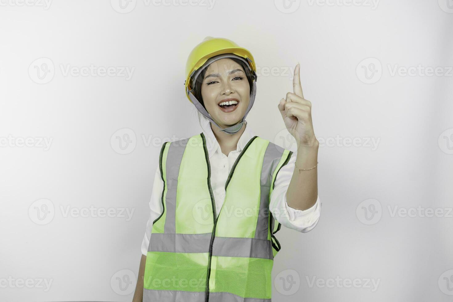 Young woman labors speaker wearing safety helmet and vest gesturing oration with hands isolated on white background. Labor's day concept. photo
