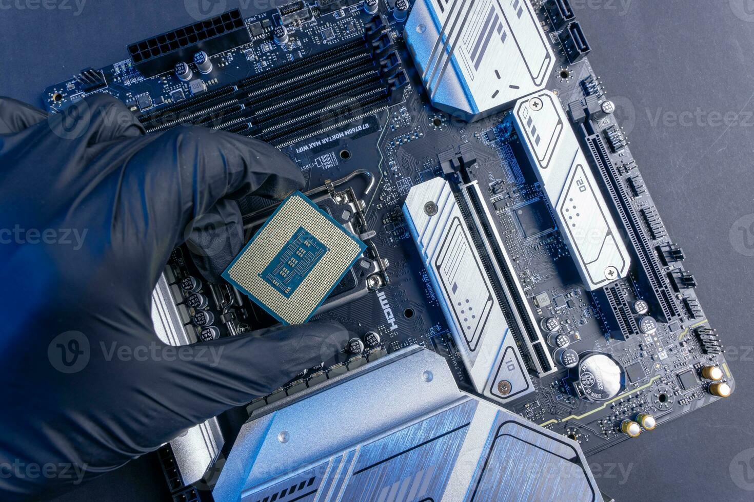 computer processor in a gloved hand against the background of the motherboard photo