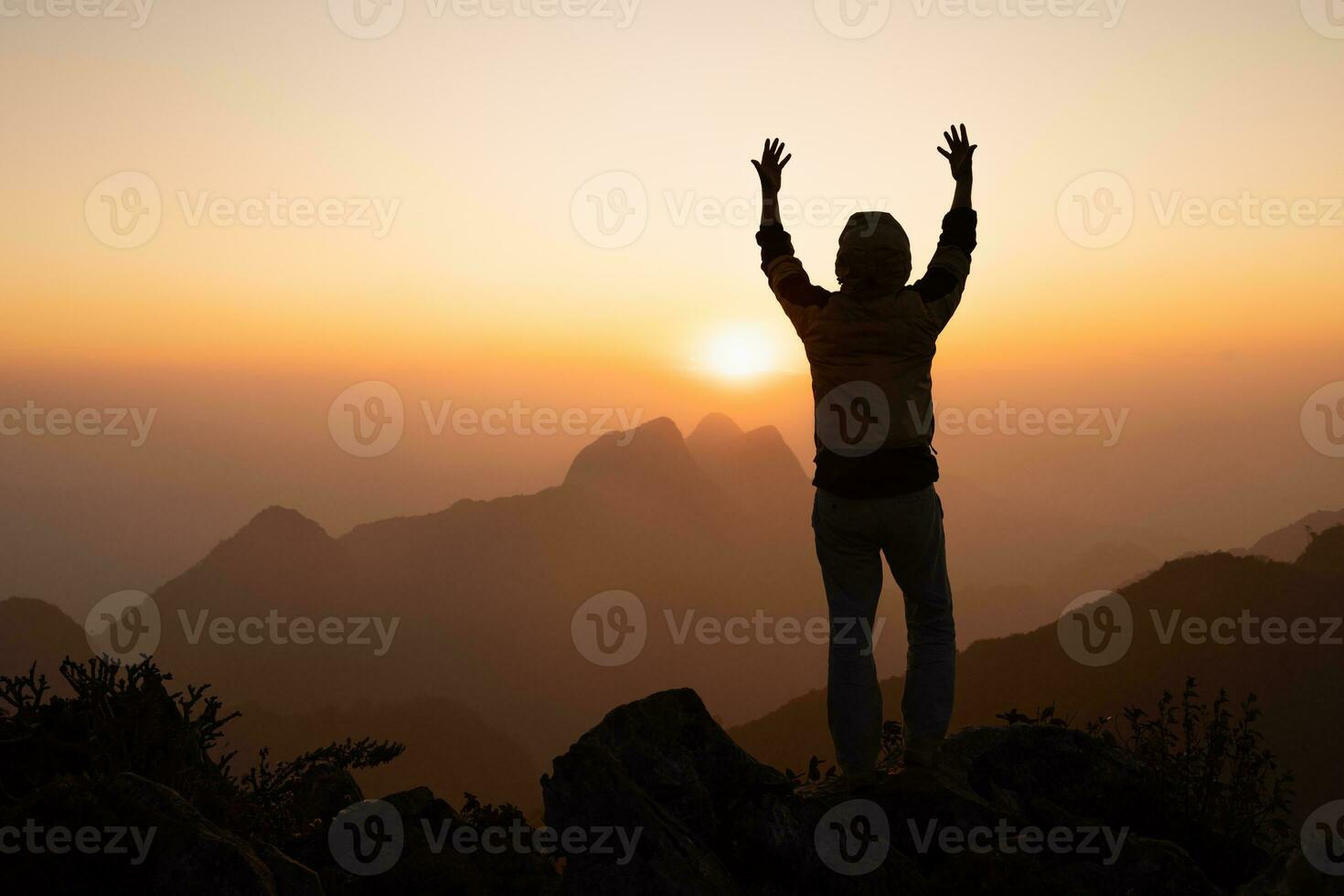 silueta de un hombre rezando con las manos con fe en la religión y la creencia en dios en el fondo del amanecer de la mañana. posición de oración. foto