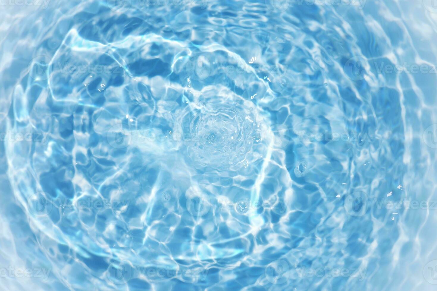 Defocus blurred transparent blue colored clear calm water surface texture with splashes and bubbles. Trendy abstract nature background. Water waves in sunlight with copy space. Blue watercolor shining photo