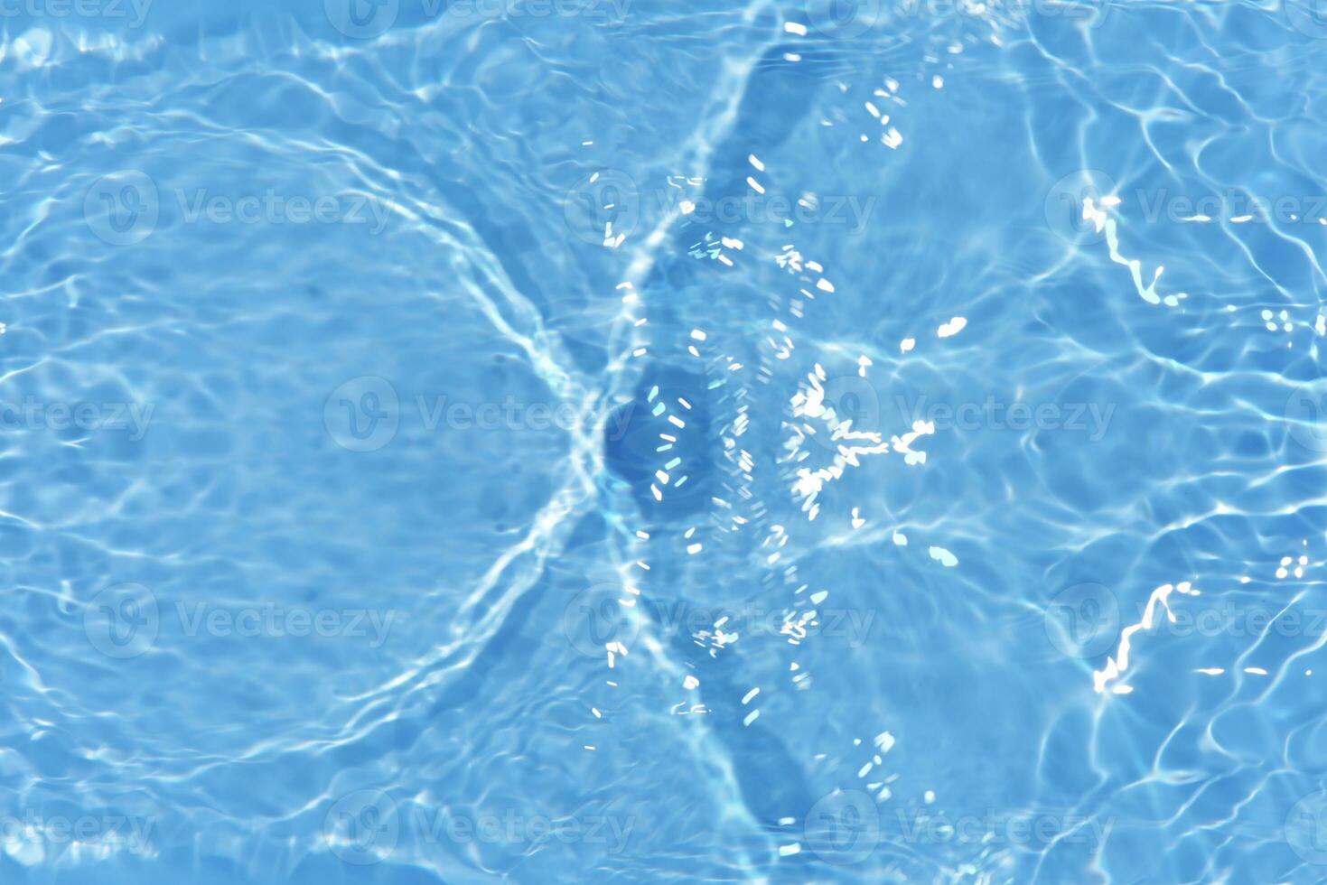 Blue water with ripples on the surface. Defocus blurred transparent blue colored clear calm water surface texture with splashes and bubbles. Water waves with shining pattern texture background. photo