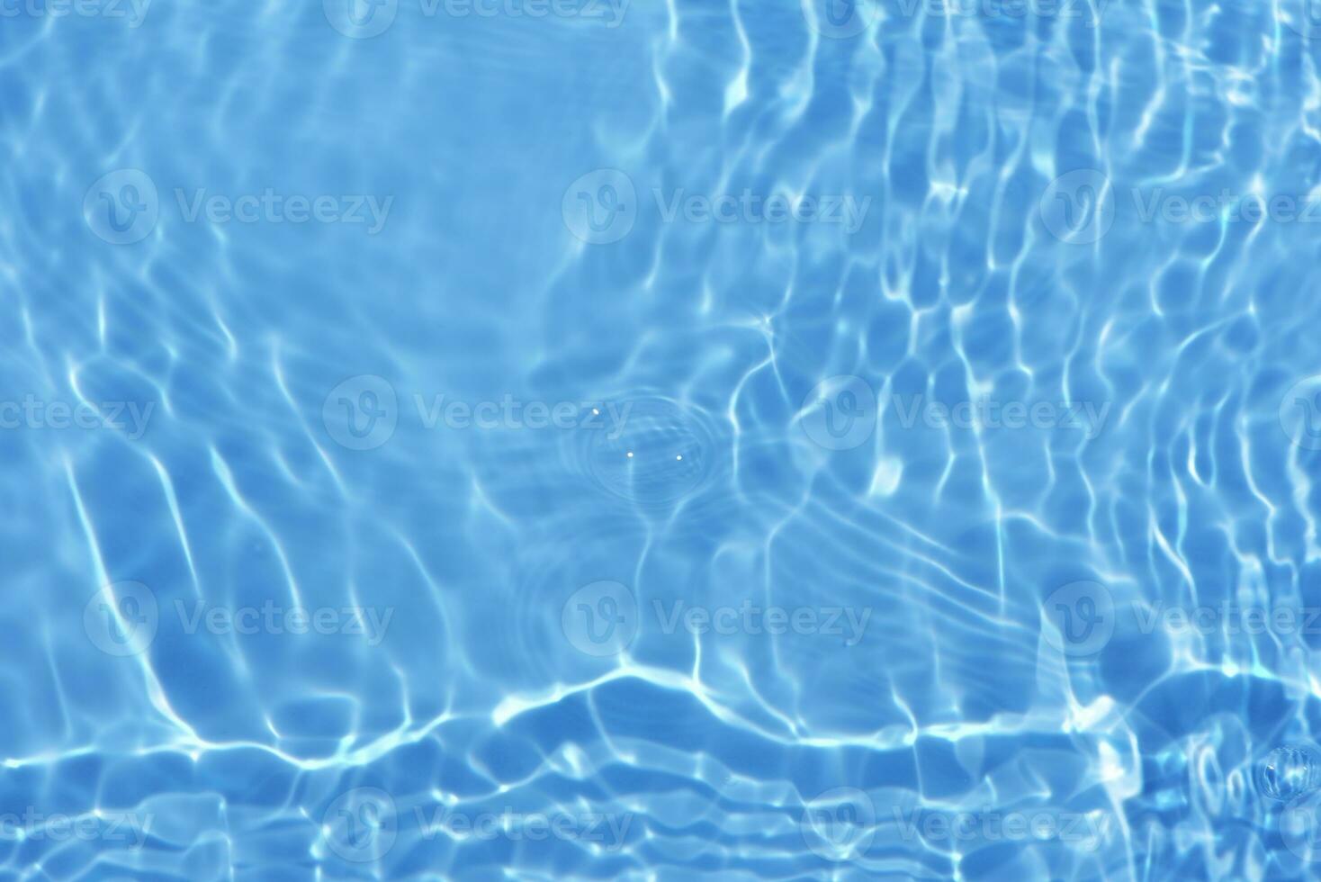 Defocus blurred transparent blue colored clear calm water surface texture with splashes and bubbles. Trendy abstract nature background. Water waves in sunlight with copy space. Blue watercolor shining photo