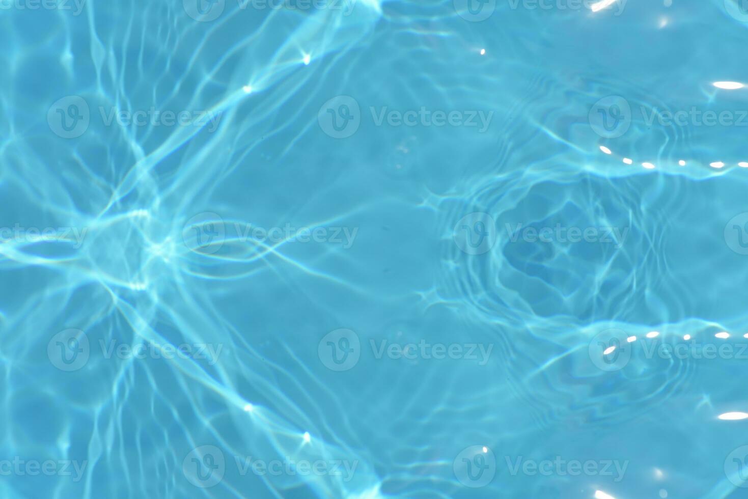 Blue water with ripples on the surface. Defocus blurred transparent blue colored clear calm water surface texture with splashes and bubbles. Water waves with shining pattern texture background. photo