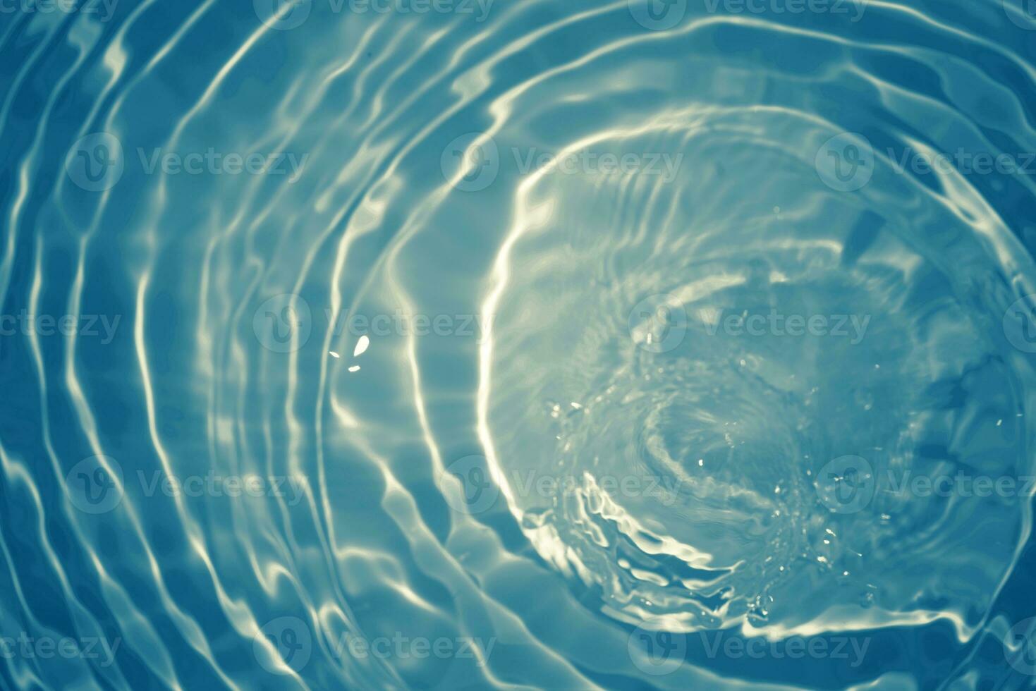 Defocus blurred transparent blue colored clear calm water surface texture with splashes and bubbles. Trendy abstract nature background. Water waves in sunlight with copy space. Blue watercolor shining photo