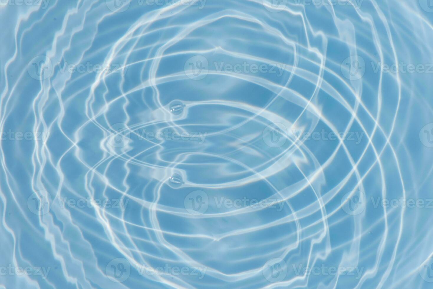 Blue water with ripples on the surface. Defocus blurred transparent blue colored clear calm water surface texture with splashes and bubbles. Water waves with shining pattern texture background. photo