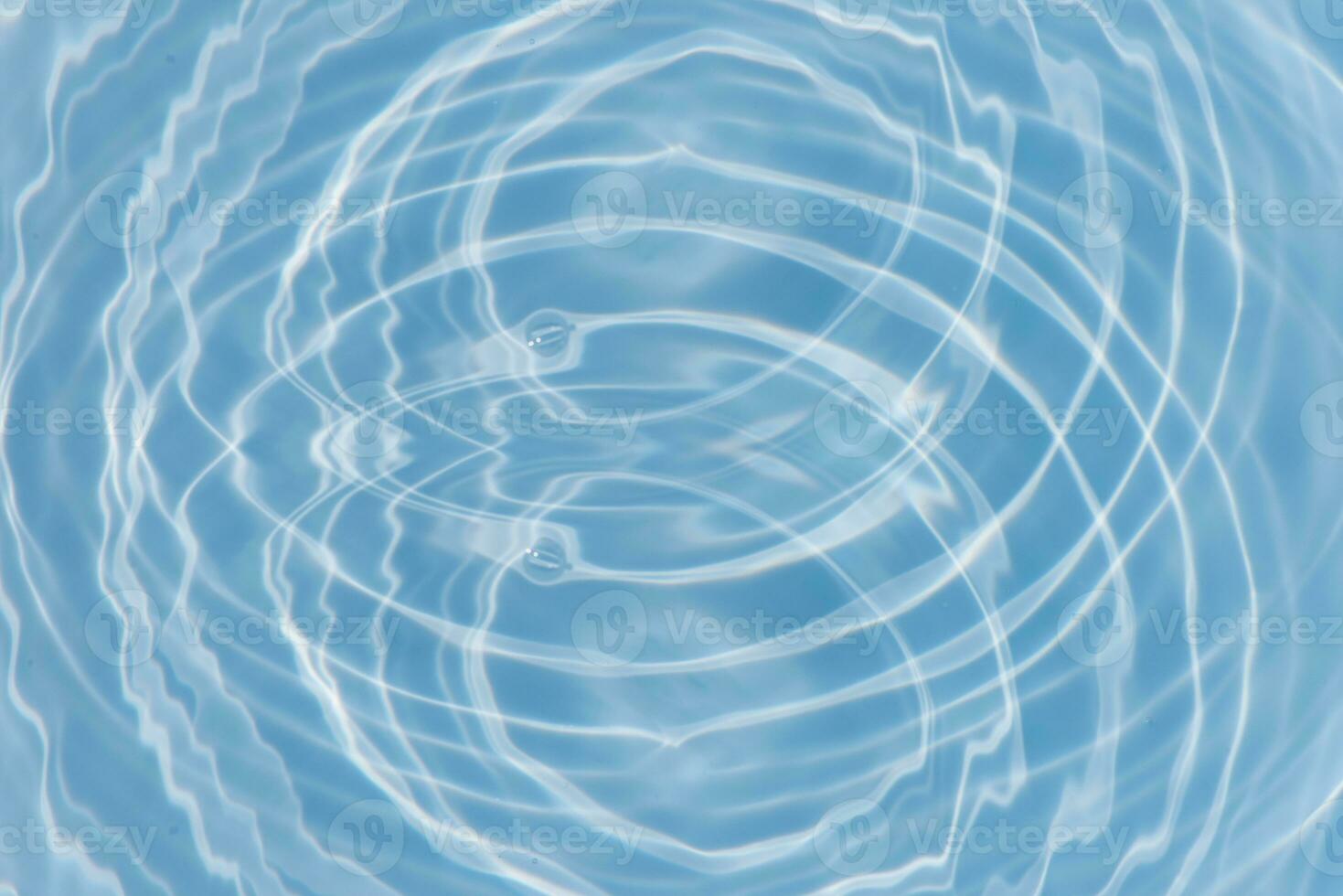 Blue water with ripples on the surface. Defocus blurred transparent blue colored clear calm water surface texture with splashes and bubbles. Water waves with shining pattern texture background. photo