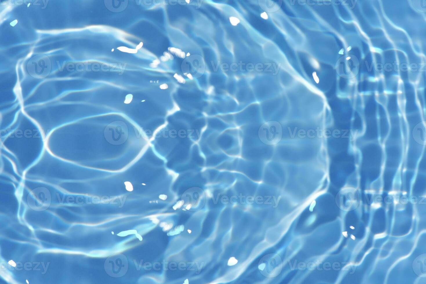 Blue water with ripples on the surface. Defocus blurred transparent blue colored clear calm water surface texture with splashes and bubbles. Water waves with shining pattern texture background. photo