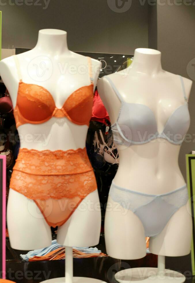 A mannequin stands on a display window in a supermarket. photo