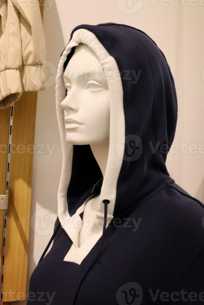 A mannequin stands on a display window in a supermarket. photo