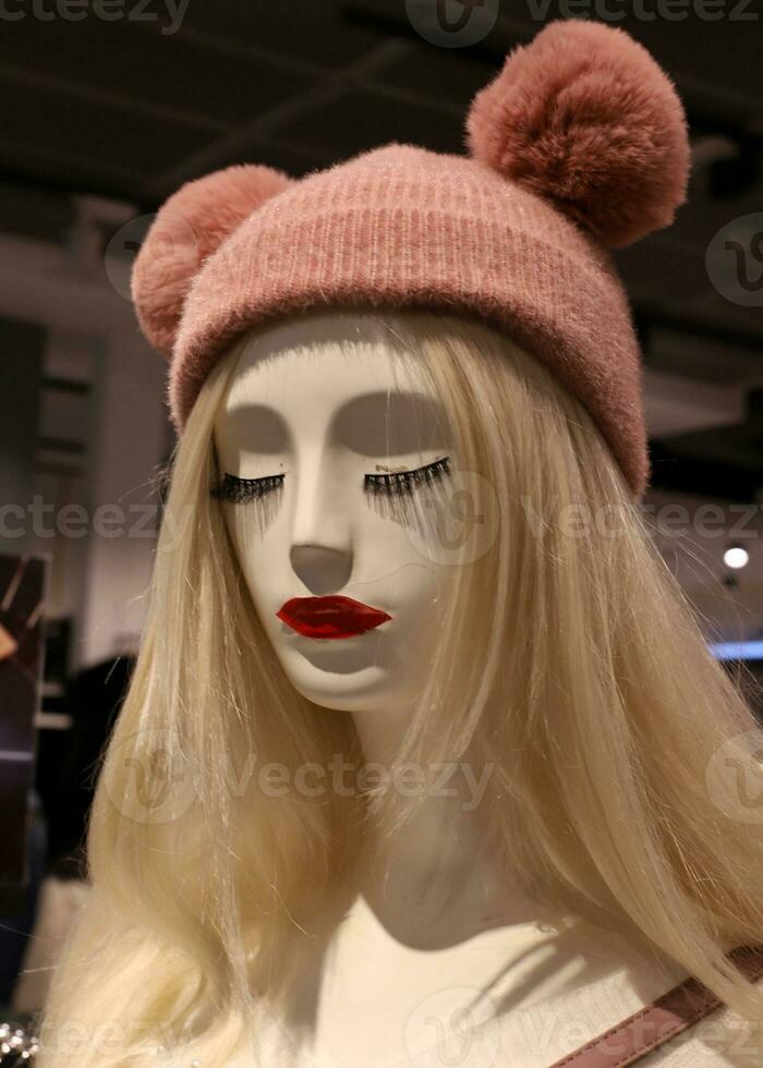 A mannequin stands on a display window in a supermarket. photo