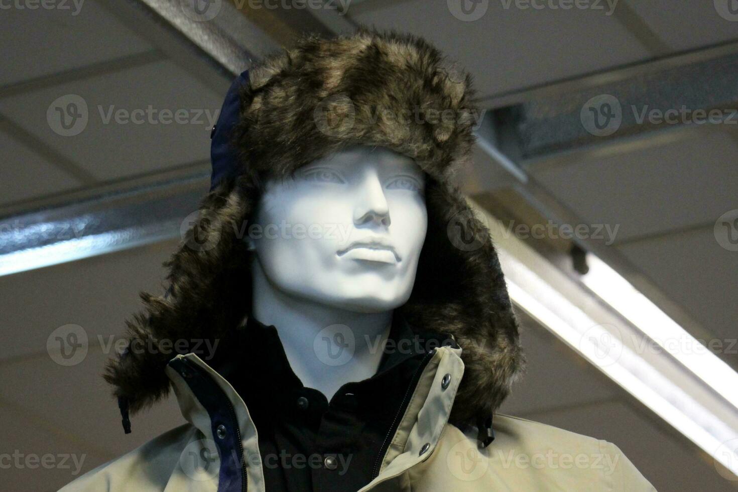 A mannequin stands on a display window in a supermarket. photo
