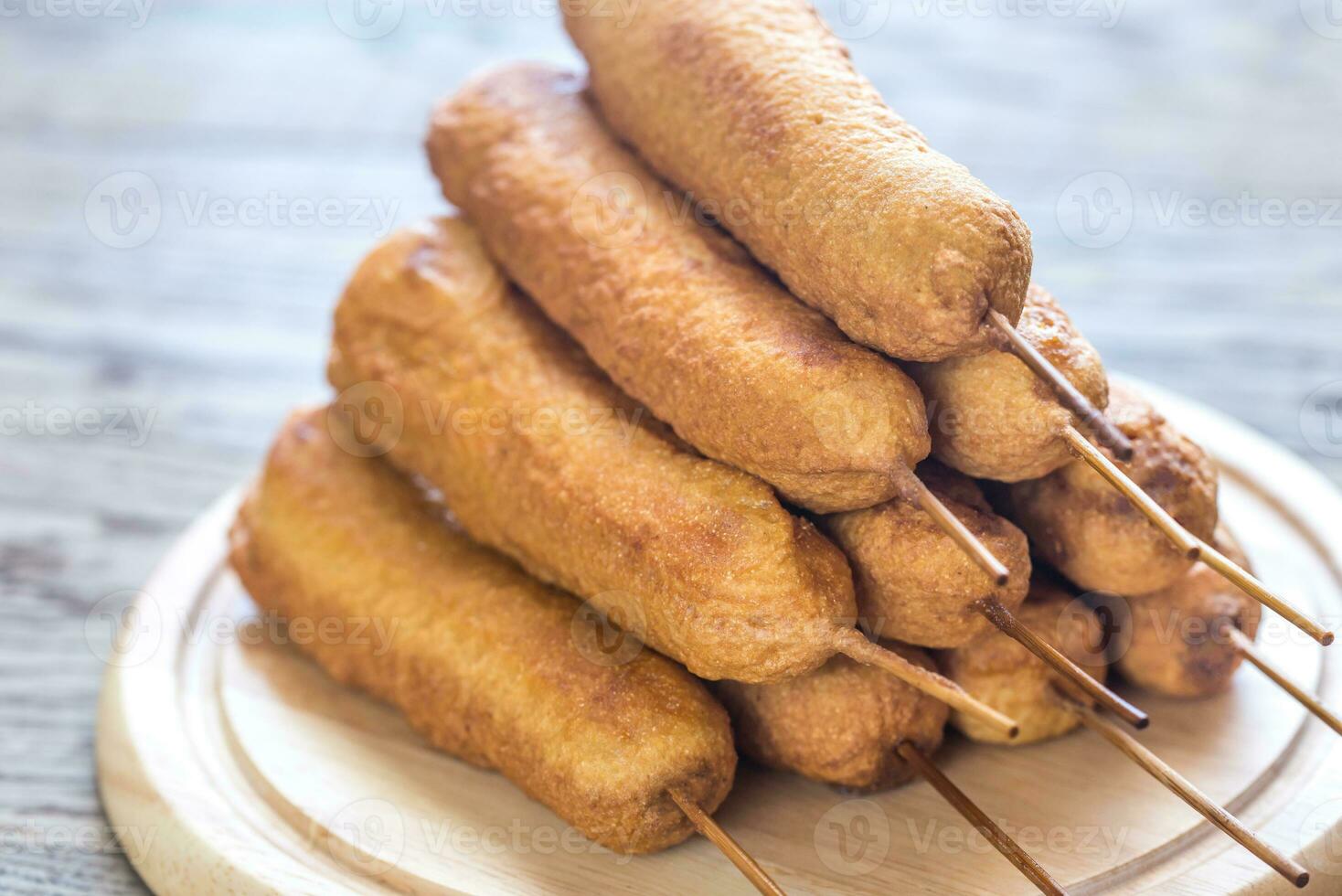 Stack of corn dogs on the wooden board photo