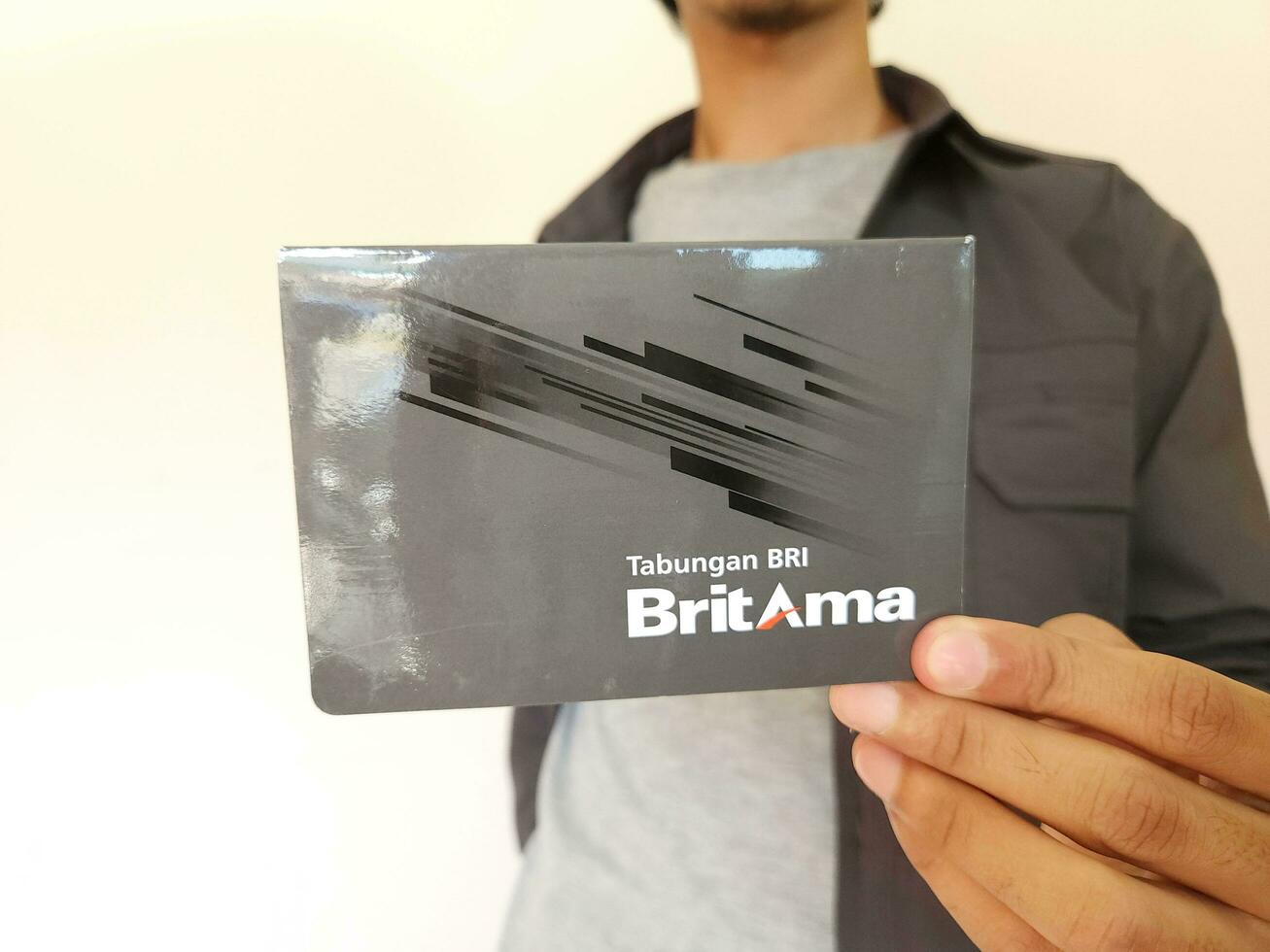 man holding BRI Britama bank passbook saving books photo