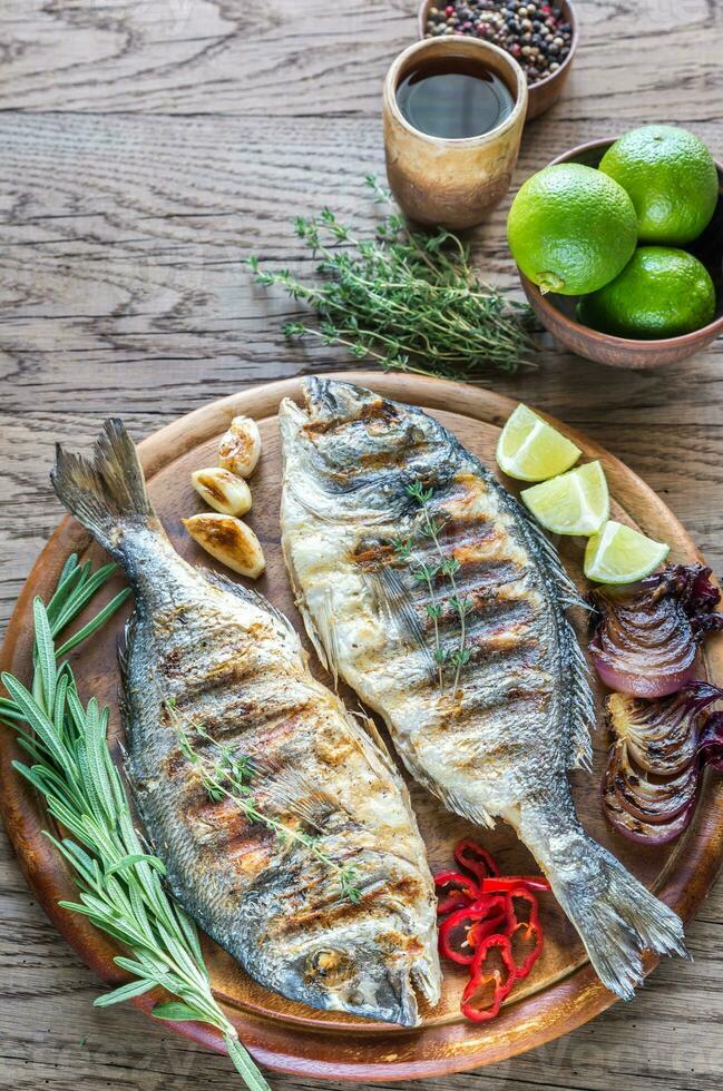 Grilled Dorade Royale Fish on the wooden board photo