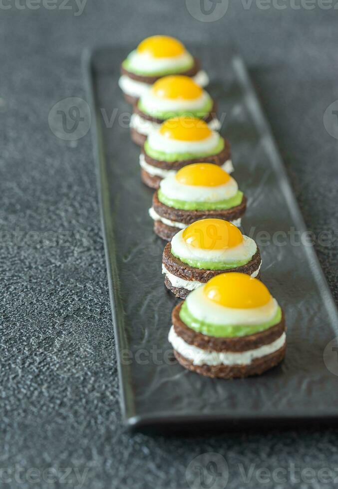 Canape with fried quail eggs photo