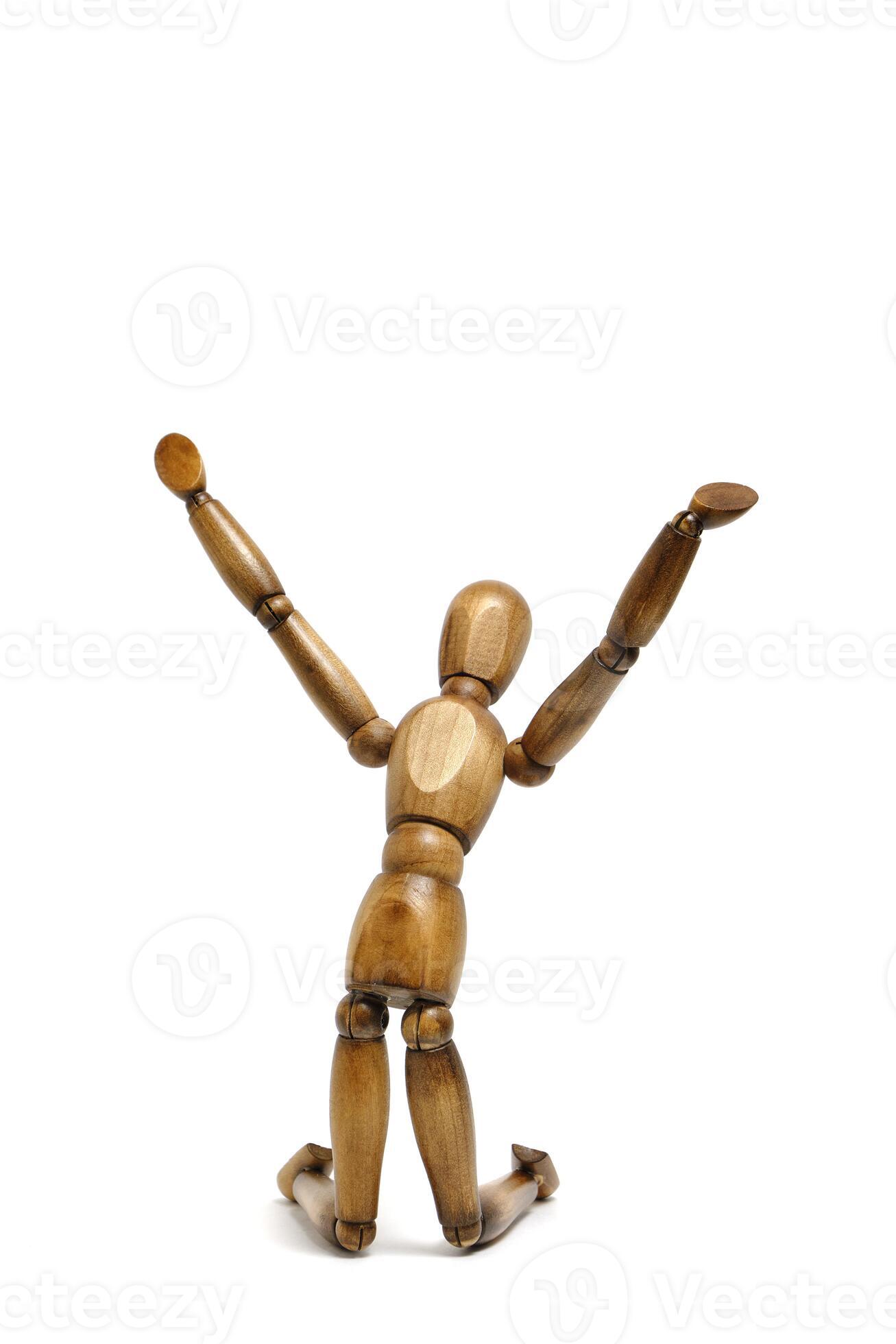 Figure wooden mannequin kneeling with his hands raised up. 32063656