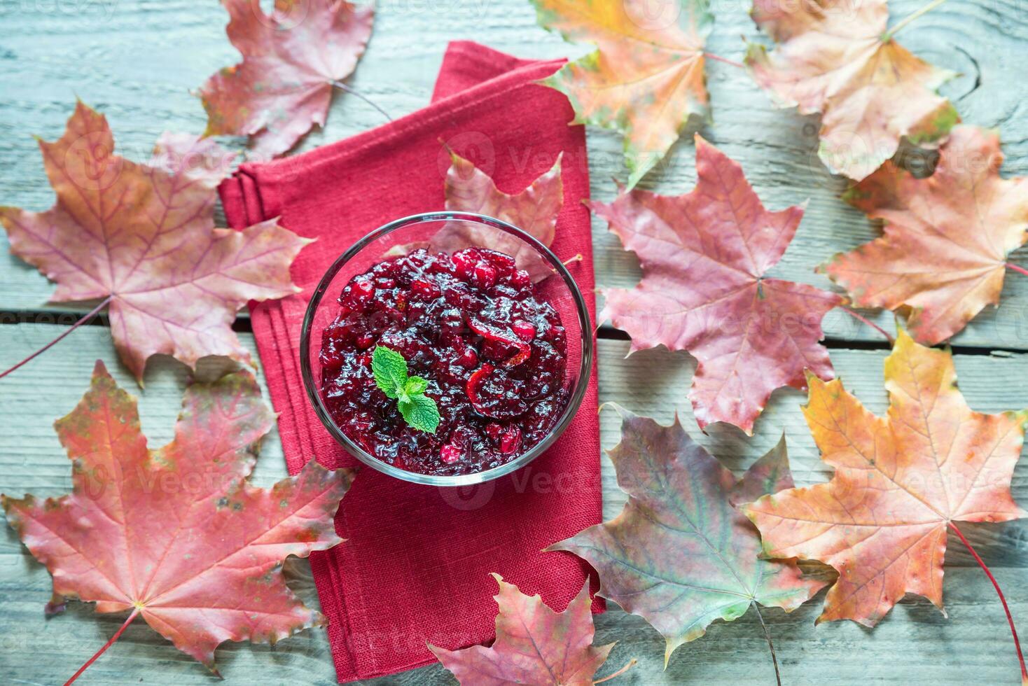 Bowl of cranberry sauce on the wooden board photo