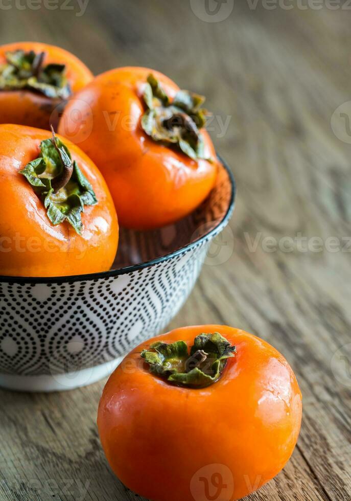 Bowl of fresh persimmons photo