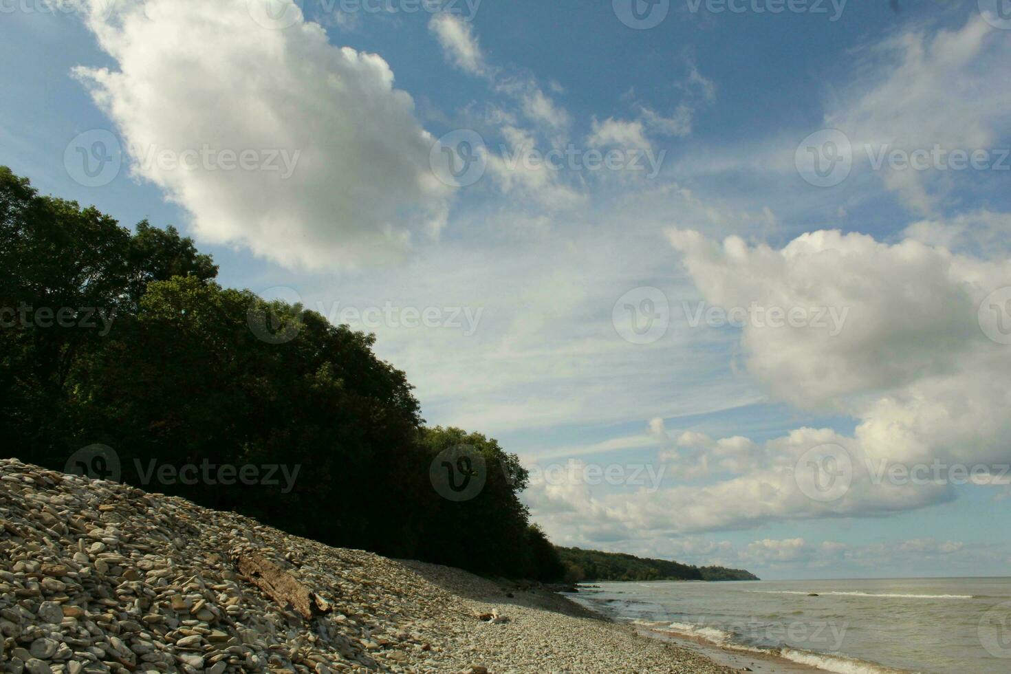 Low angle view of orange cliffs near the sandy shore of the Baltic Sea. Summer holidays in Estonia. Idyllic landscape. National landmark, travel, sightseeing, environmental conservation photo