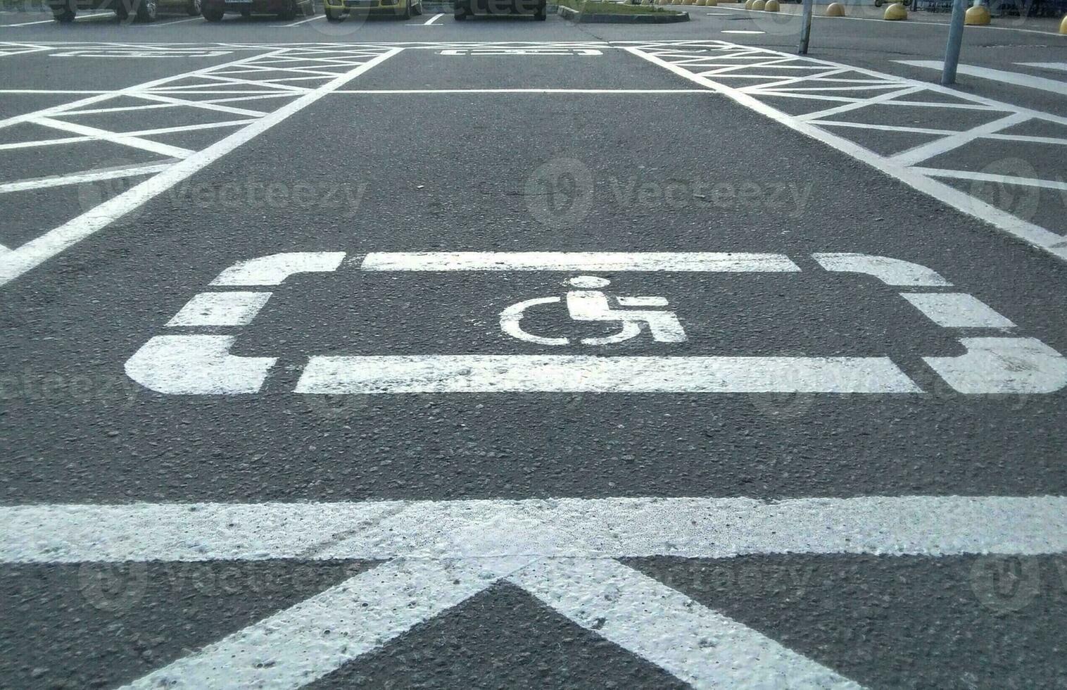 Handicap symbol on road, traffic and pedestrians in background photo