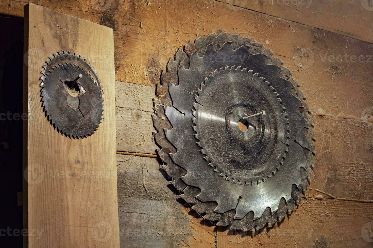 set of circular saw blades hangs on a wooden wall in the carpentry workshop. Circular saw. old rustic carpentry workshop. photo