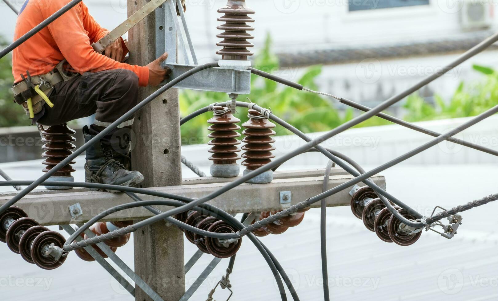 High voltage power line maintenance. Electrician at work. Electrical technician working on electric pole. High voltage power line construction. Danger of wiring and electrical wires. Work with safety. photo