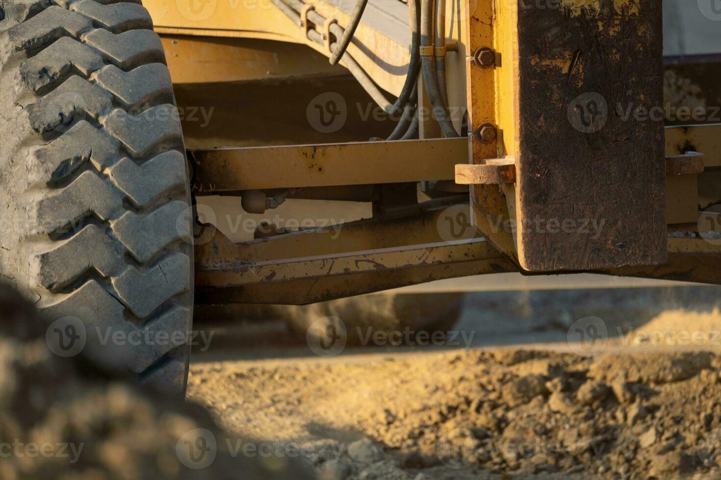 Road grader working at construction site for maintenance and construction of dirts and gravel road. Yellow motor grader. Heavy machinery and construction equipment for grading roads. Grader machine. photo