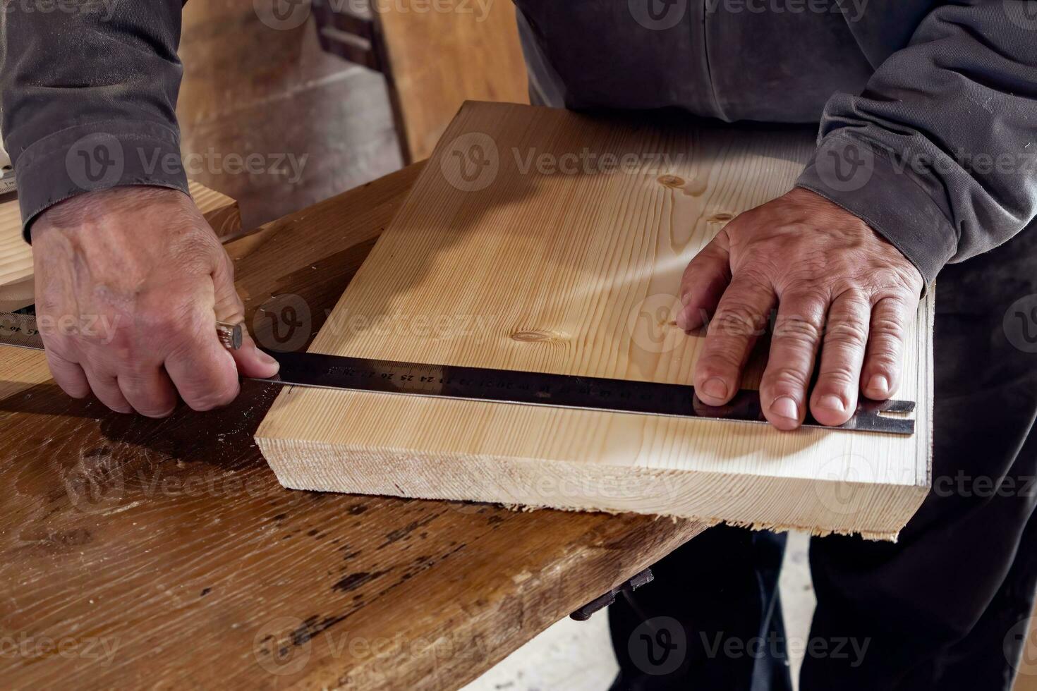 male carpenter marks out a wooden board with a ruler and pencil in his home workshop. working with wood. photo