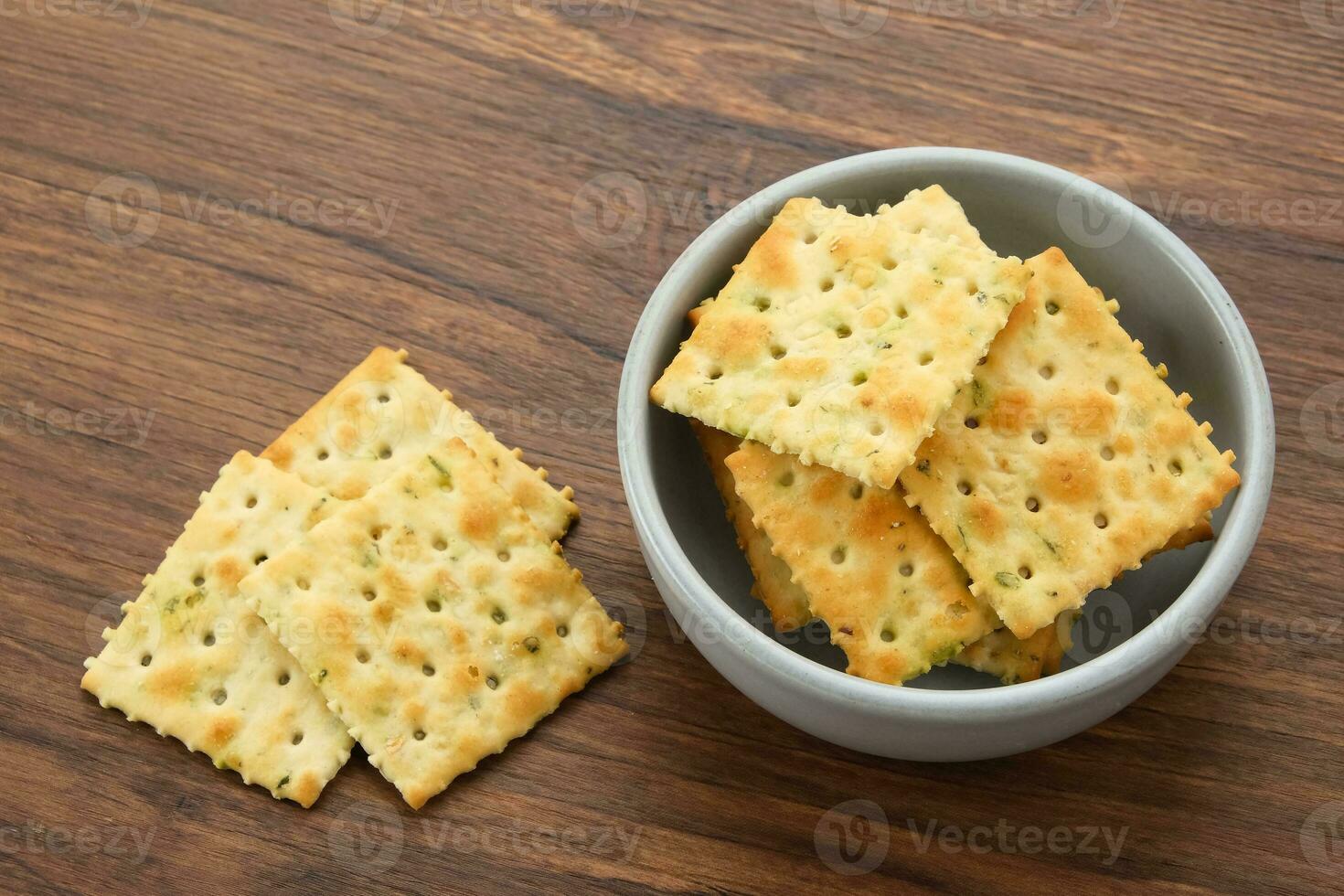 Stacked square biscuits, with a sprinkling of dry vegetables, savory and crunchy photo