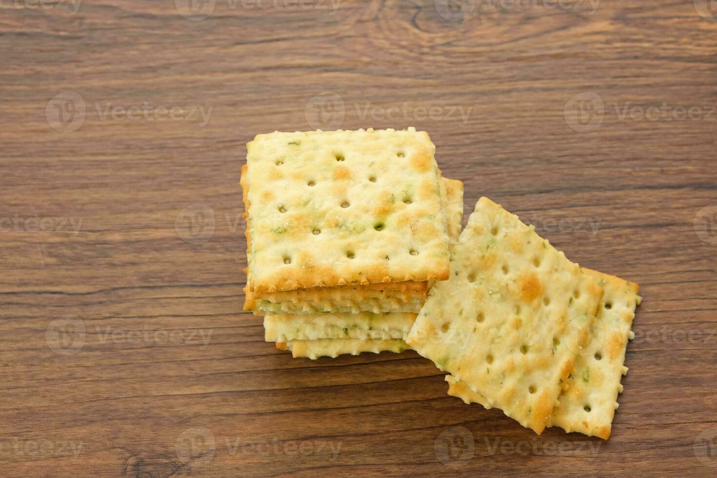Stacked square biscuits, with a sprinkling of dry vegetables, savory and crunchy photo