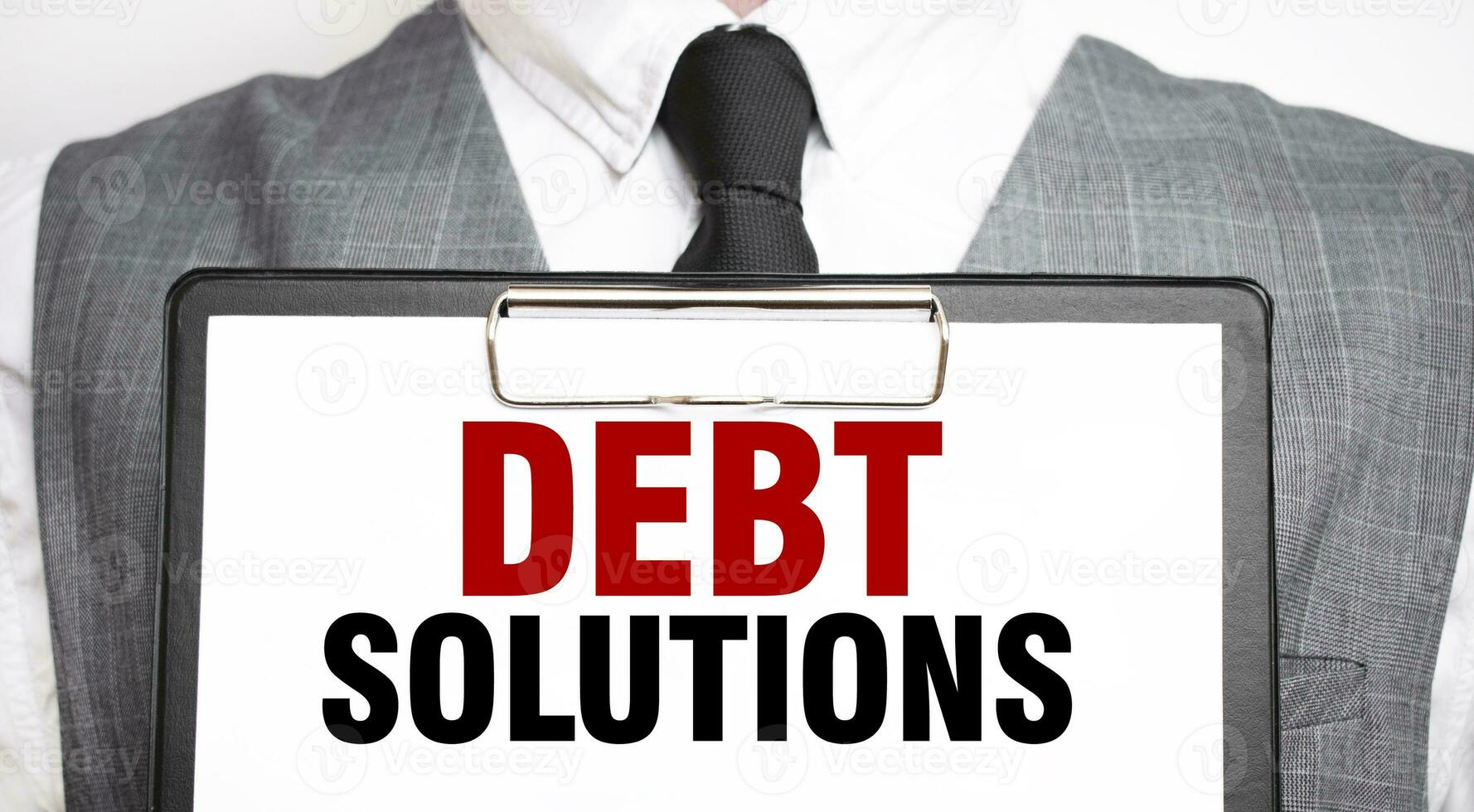 Businessman holding sheet of paper with a message DEBT SOLUTIONS photo